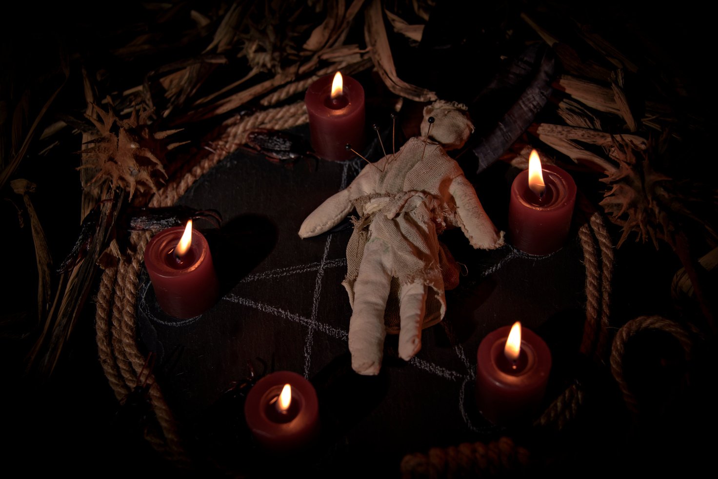 Occultist dripping hot wax on voodoo doll, magic rituals, black spell, horror.