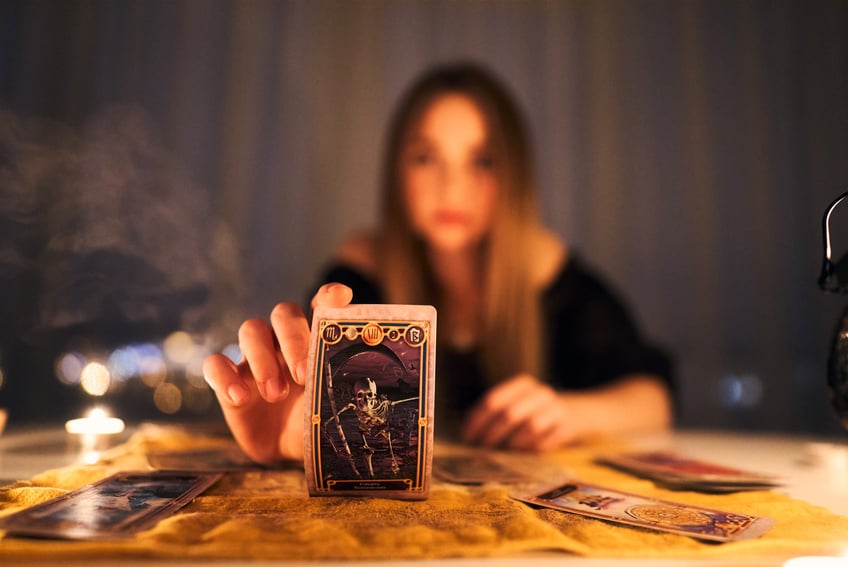 Woman Using Tarot Card in Dark Room