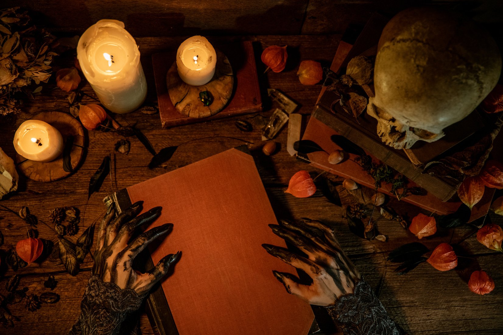 Witches hands holding book of shadows, top down view.